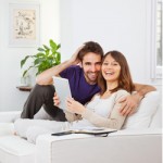 Young couple sitting on the couch planning to buy a home