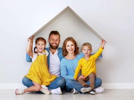 Family with two children sitting under a symbolic roof outline, smiling and portraying a happy, secure home life.
