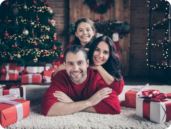 A family of three celebrating in front of a christmas tree.