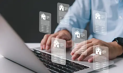 Hands on a laptop with virtual property documents, representing mortgage updates.