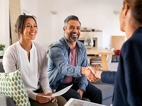 Smiling couple meeting with an agent, celebrating their fast mortgage approval.