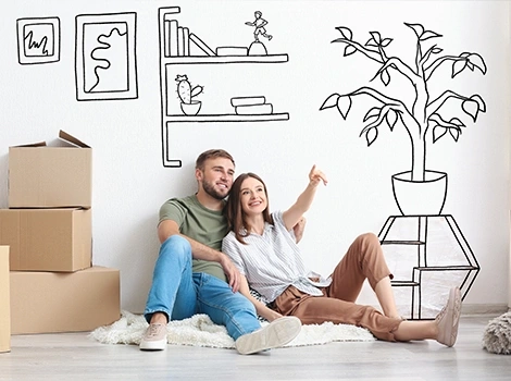 Young couple sitting on the floor with unpacked boxes, imagining their new home's interior, with hand-drawn sketches on the wall.